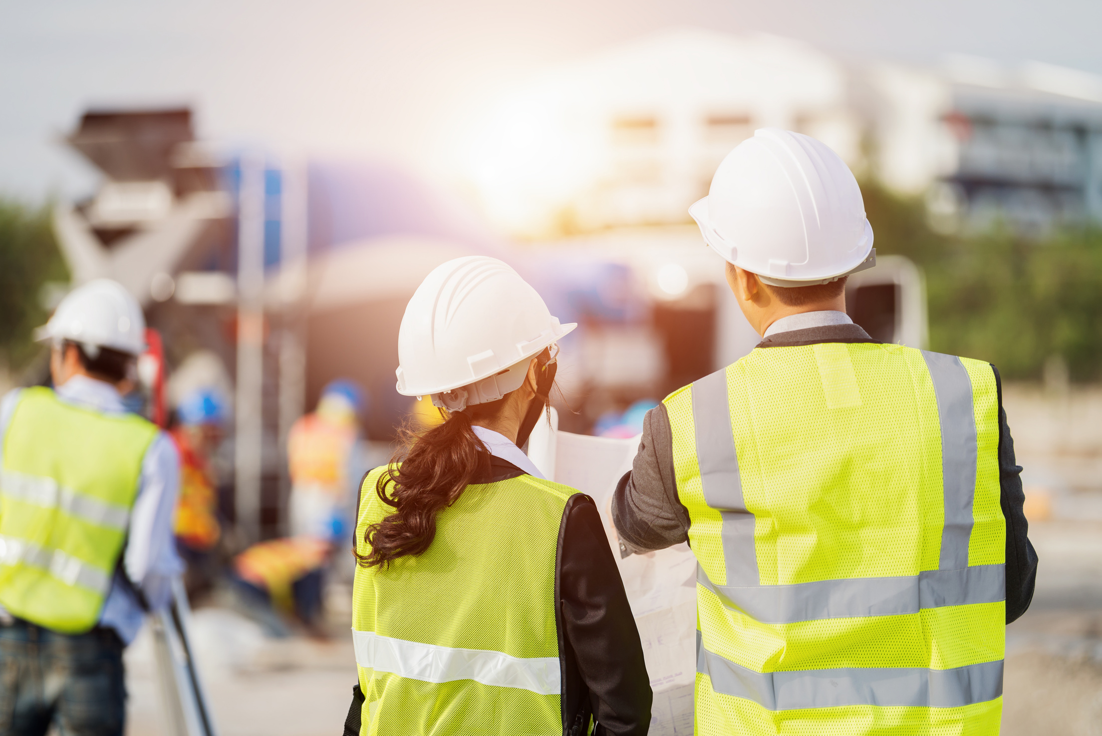 Businessman and businesswoman using see plan paper at construction site